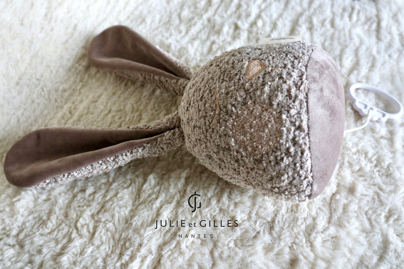 Doudou musical Made in France aux berceuses originales et soporifiques.La collection Doux lapins de Gilles et Julie a été conçue pour endormir bébé en douceur . Ce doudou musical aux longues oreilles pourra aisément s'attacher sur un lit à barreau ou bien même sur un porte manteau . Lignes épurées et style non genré les doux lapins proposent des berceuses plus originales les unes que les que les autres . Coloris beige bouclé.