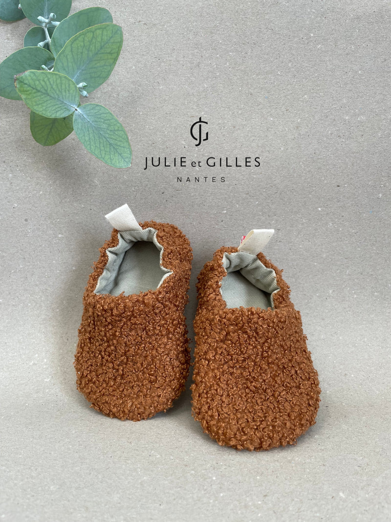 Chaussons bébé Julie et Gilles en tissu sherpa bouclé orangé, doublés en coton 100 % naturel, alliant douceur et confort, fabriqués avec soin en France.