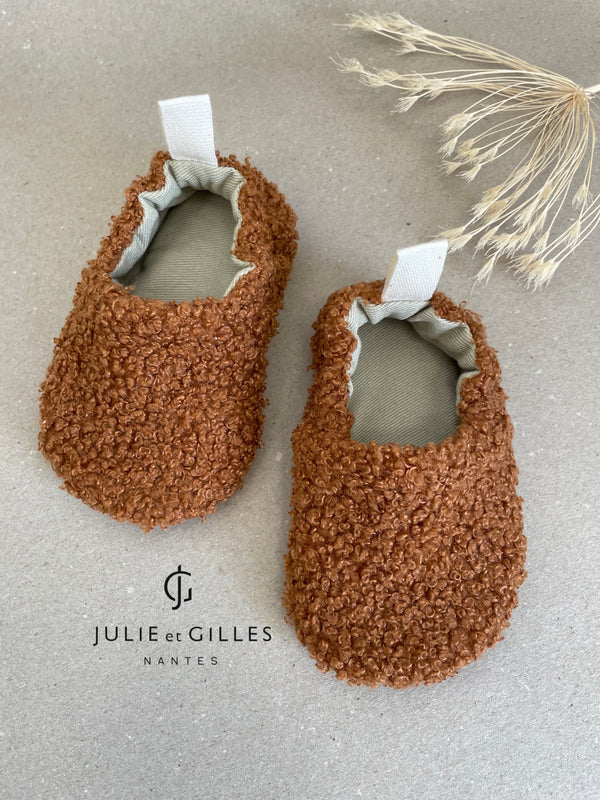 Chaussons bébé Julie et Gilles en tissu sherpa bouclé orangé, doublés en coton 100 % naturel, alliant douceur et confort, fabriqués avec soin en France.